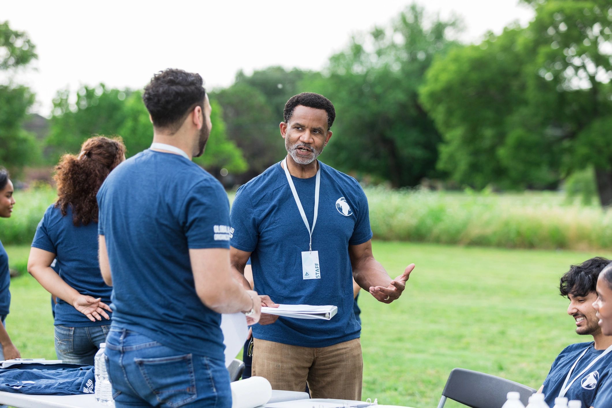 Community volunteers in discussion during an outdoor event