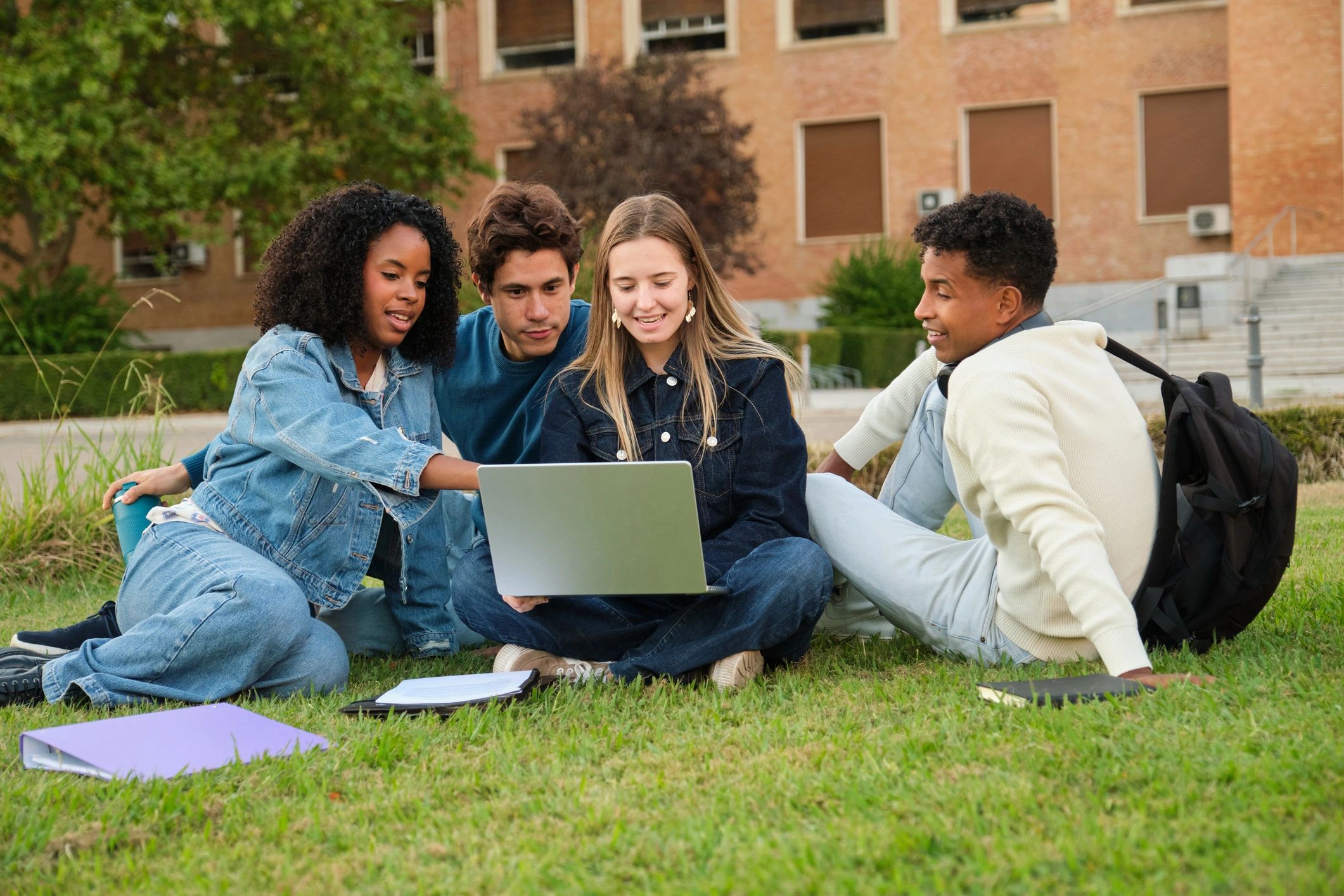 Group of students studying together on campus grass